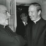 Father Monan speaking with Tomas Cardinal O'Fiaich at a state dinner