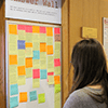 A student looks at the Answer Wall, covering in Post-its