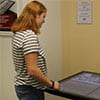 A student standing by a touch table